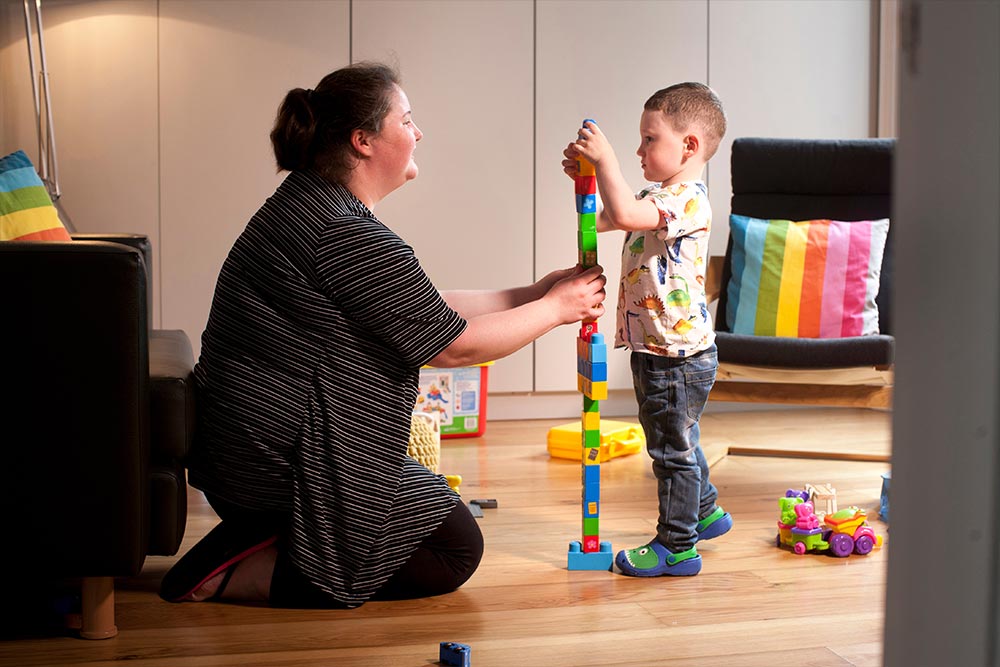 Women and child building toy tower